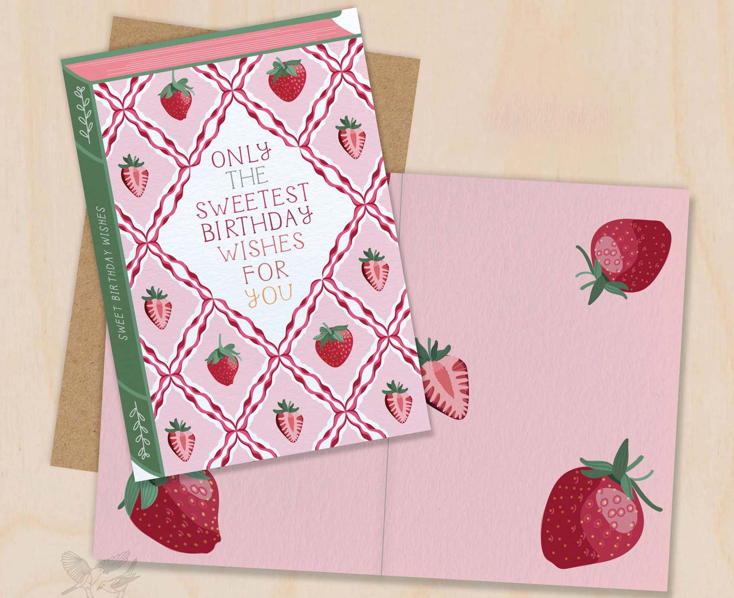 Birthday card with strawberry design and envelope on a beige background