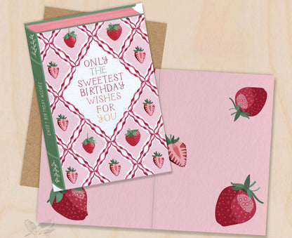 Birthday card with strawberry design and envelope on a beige background